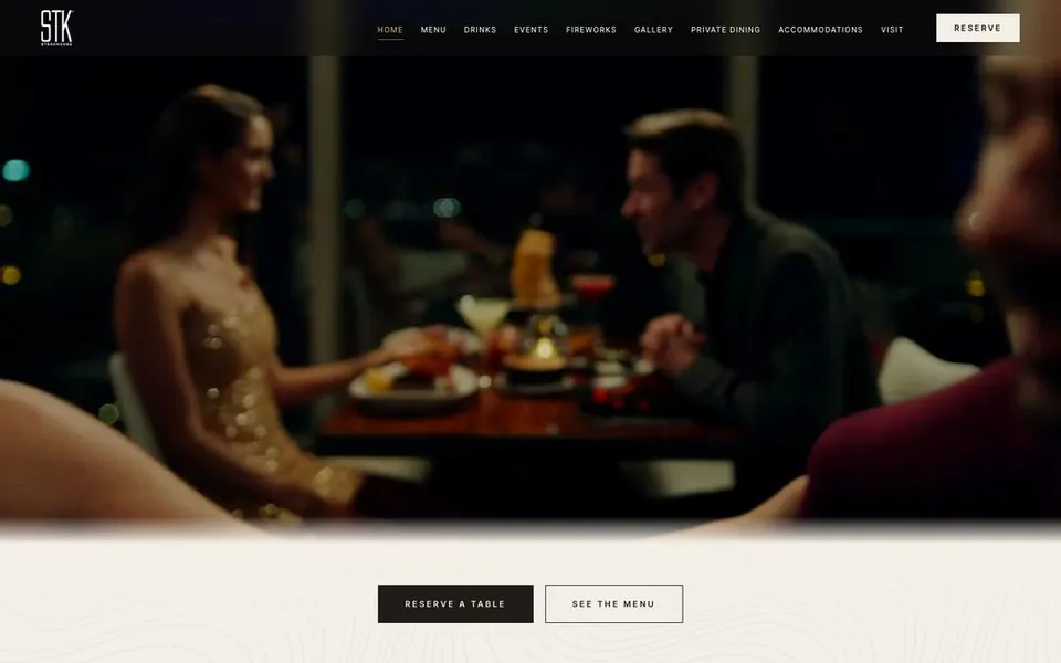 STK Niagara Falls homepage, cream navigation over a moody window-table dinner scene above the Falls